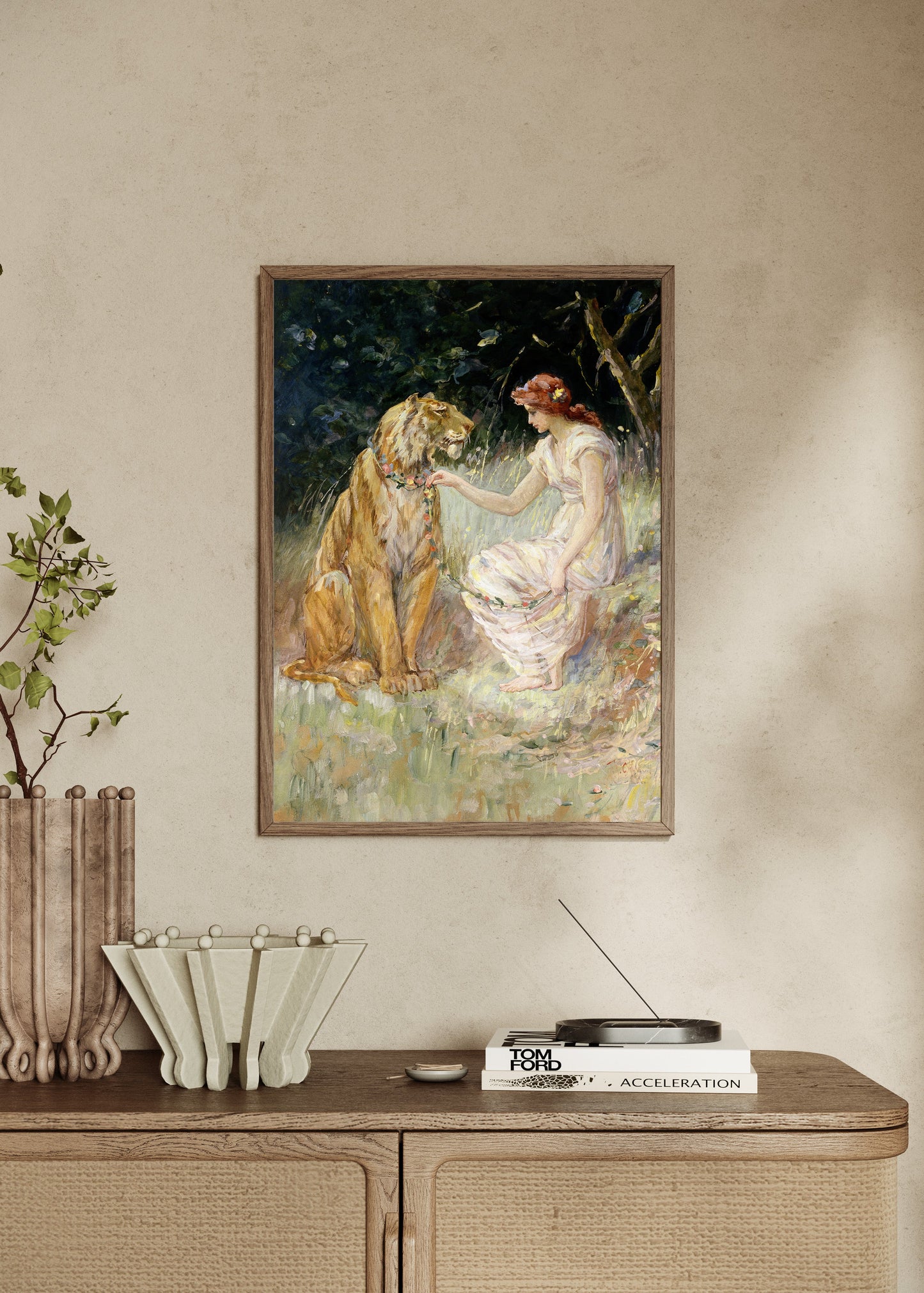 Framed artwork of a woman and a lion on a wall above a wooden console table.